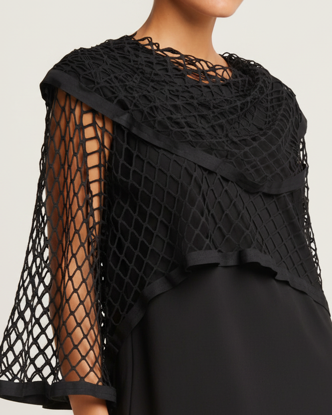 Black netted shawl lined with vegan leather draped over a person on a neutral background