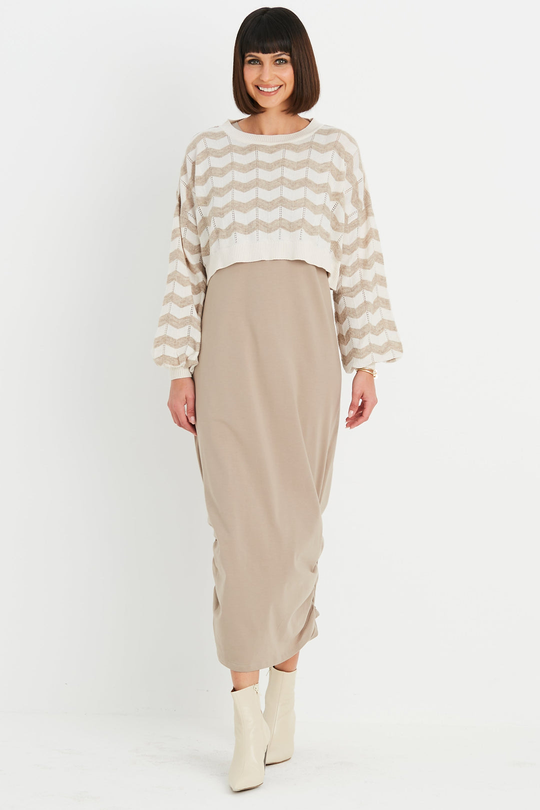 Woman wearing a striped sweater and beige skirt on a white background