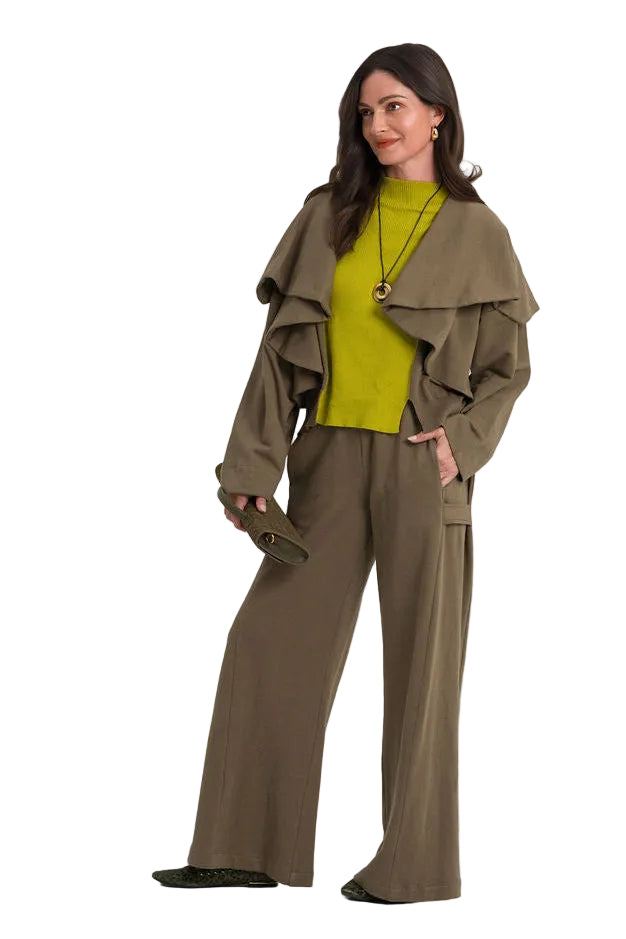 A woman modeling a matching 100% cotton olive green wide-leg pants and jacket set with a bright yellow-green top, standing against a plain white studio background.