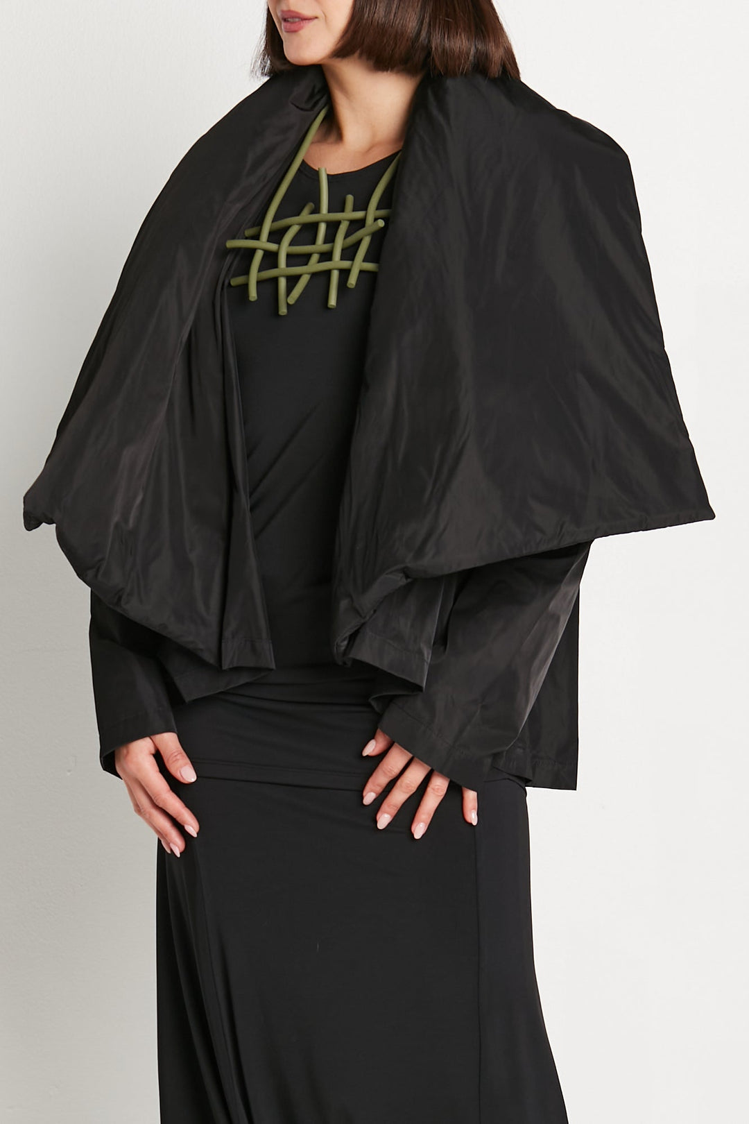 A model wearing a black nylon cascade jacket with a flowing design.