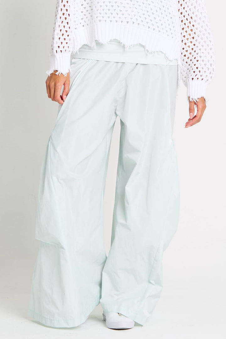 Mint wide-leg pants worn by a person on a white background