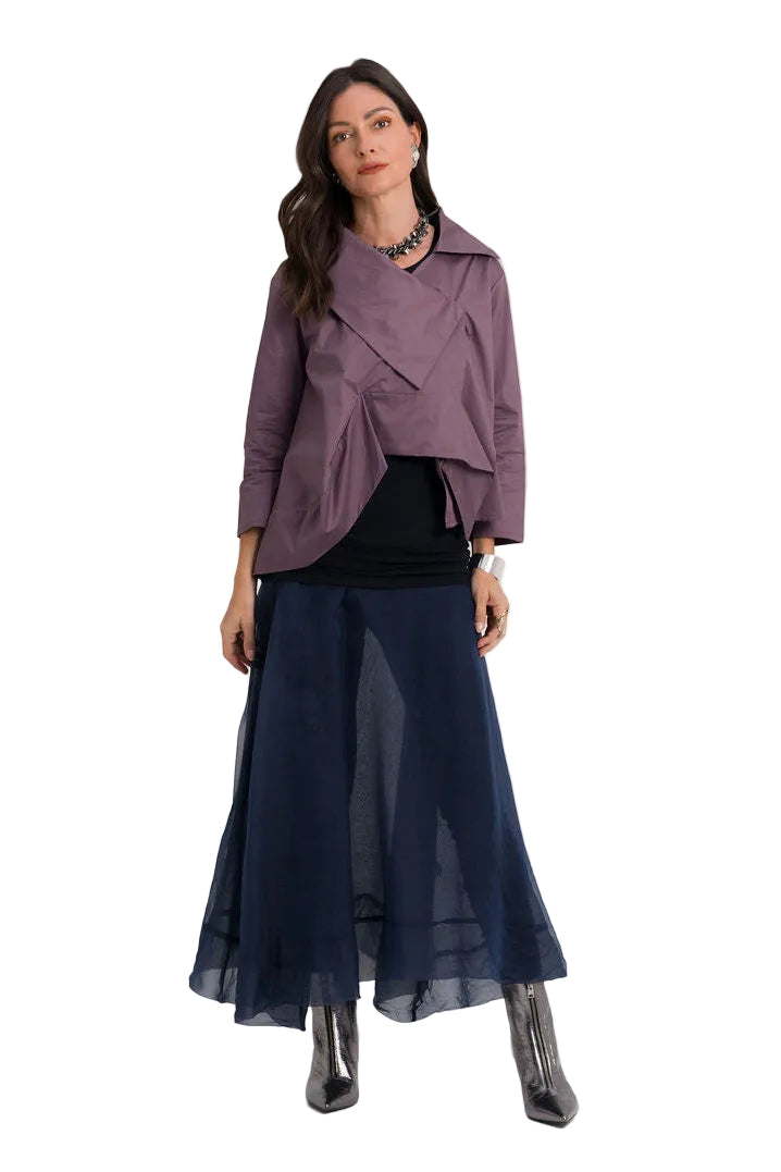 A model stands against a light gray studio background wearing a 100% cotton mauve wrap-style jacket, a black top, a long navy sheer skirt, and black pointed boots.