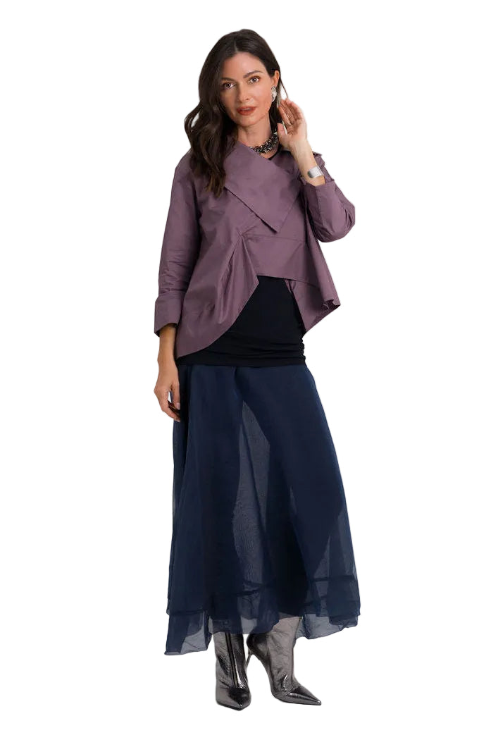 A woman modeling a three-piece outfit consisting of a dusty 100% cotton purple wrap-style jacket, a black ribbed top, and a navy blue sheer midi skirt, paired with dark pointed-toe boots, against a solid light gray background.