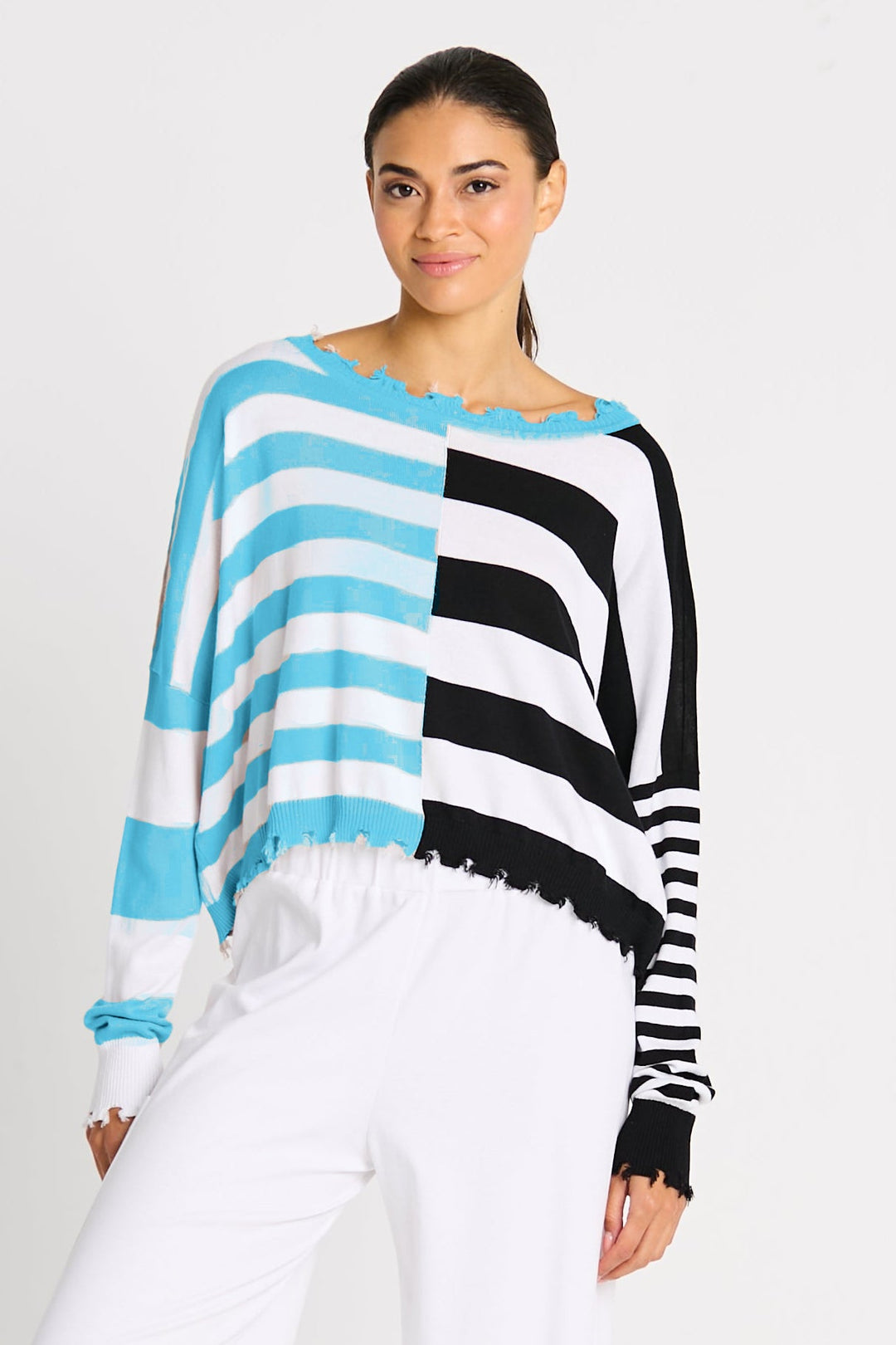 Woman wearing a black, white, and beige striped sweater on a white background