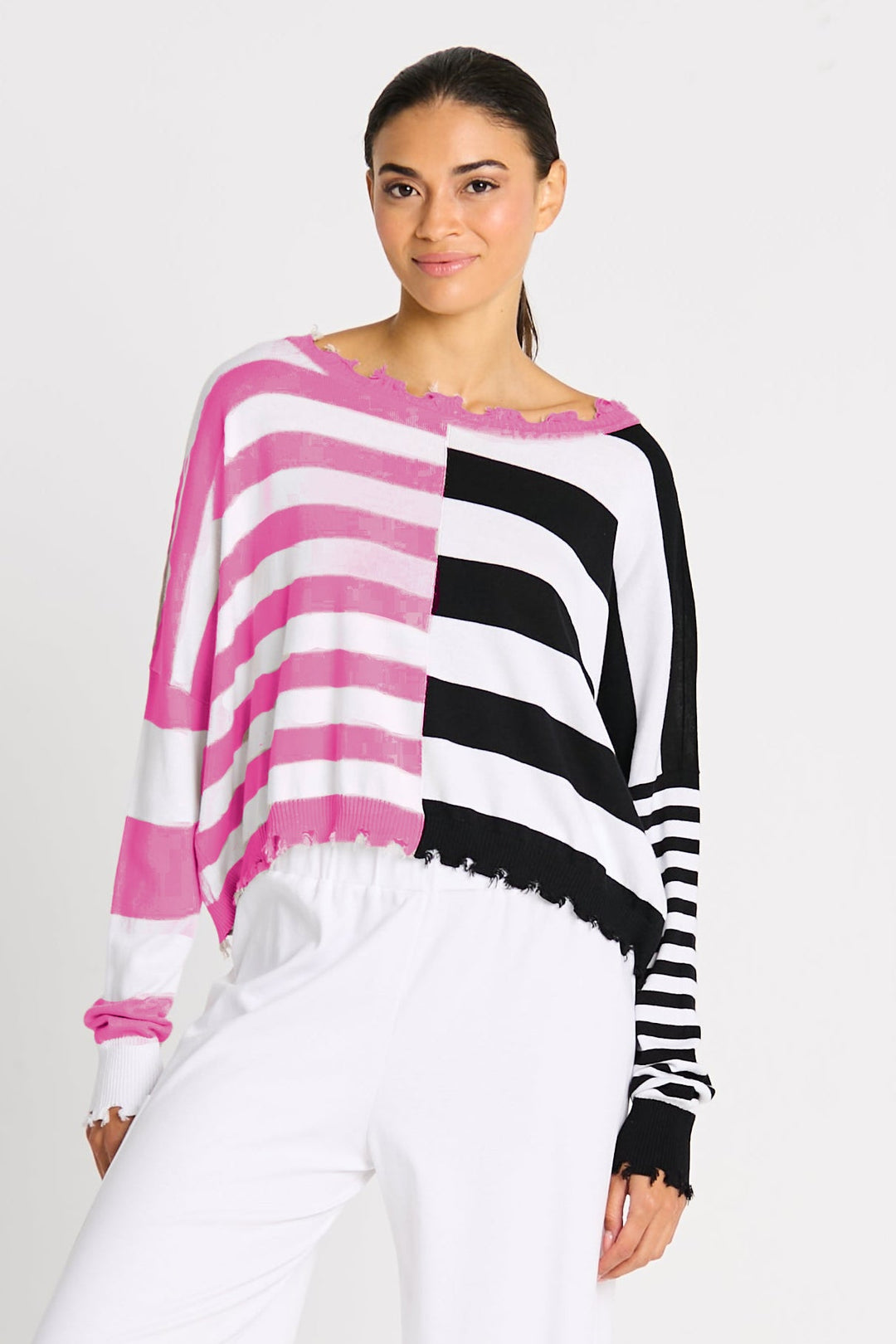 Woman wearing a black and white striped sweater with wide-leg pants on a white background