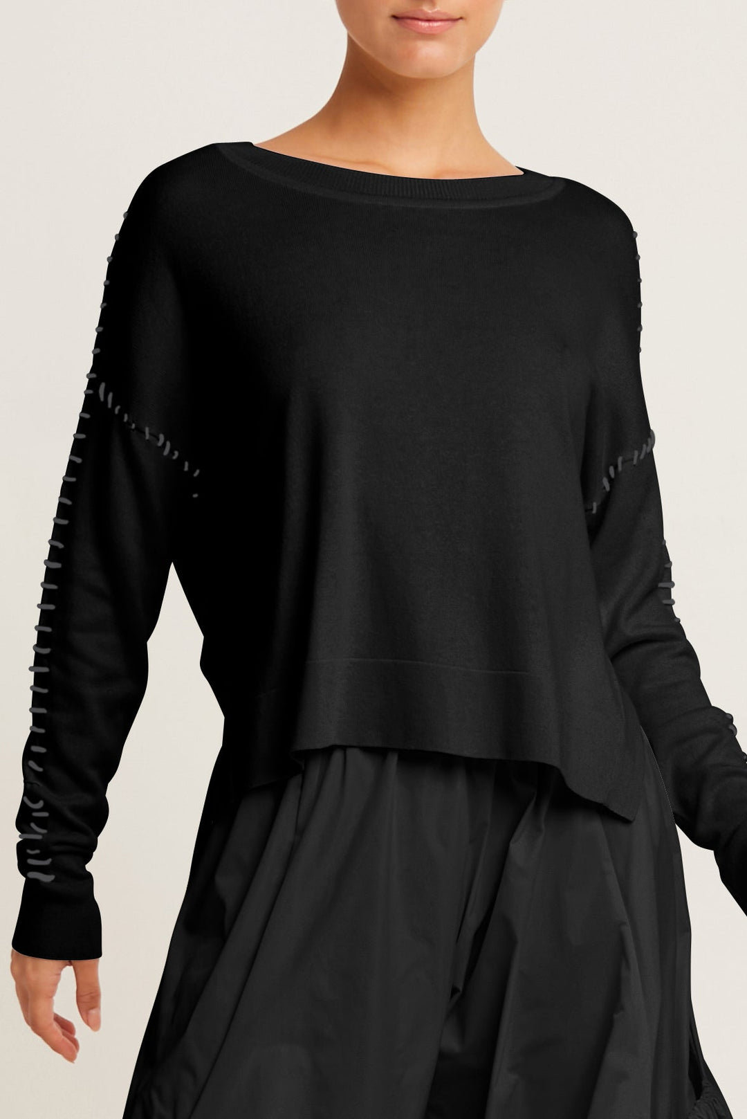 Black long-sleeve [ima cotton sweater with textured sleeves on a plain background