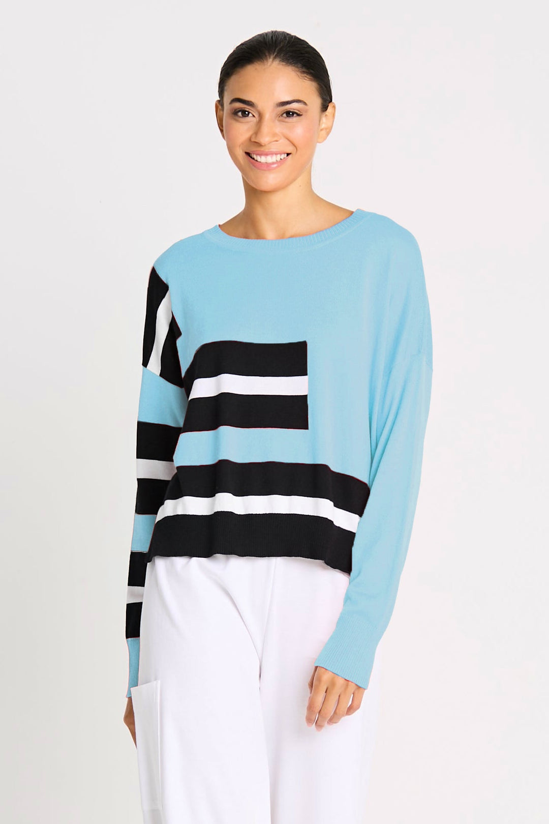 Woman wearing a pink, black, and white striped long-sleeve pima cotton top on a white background