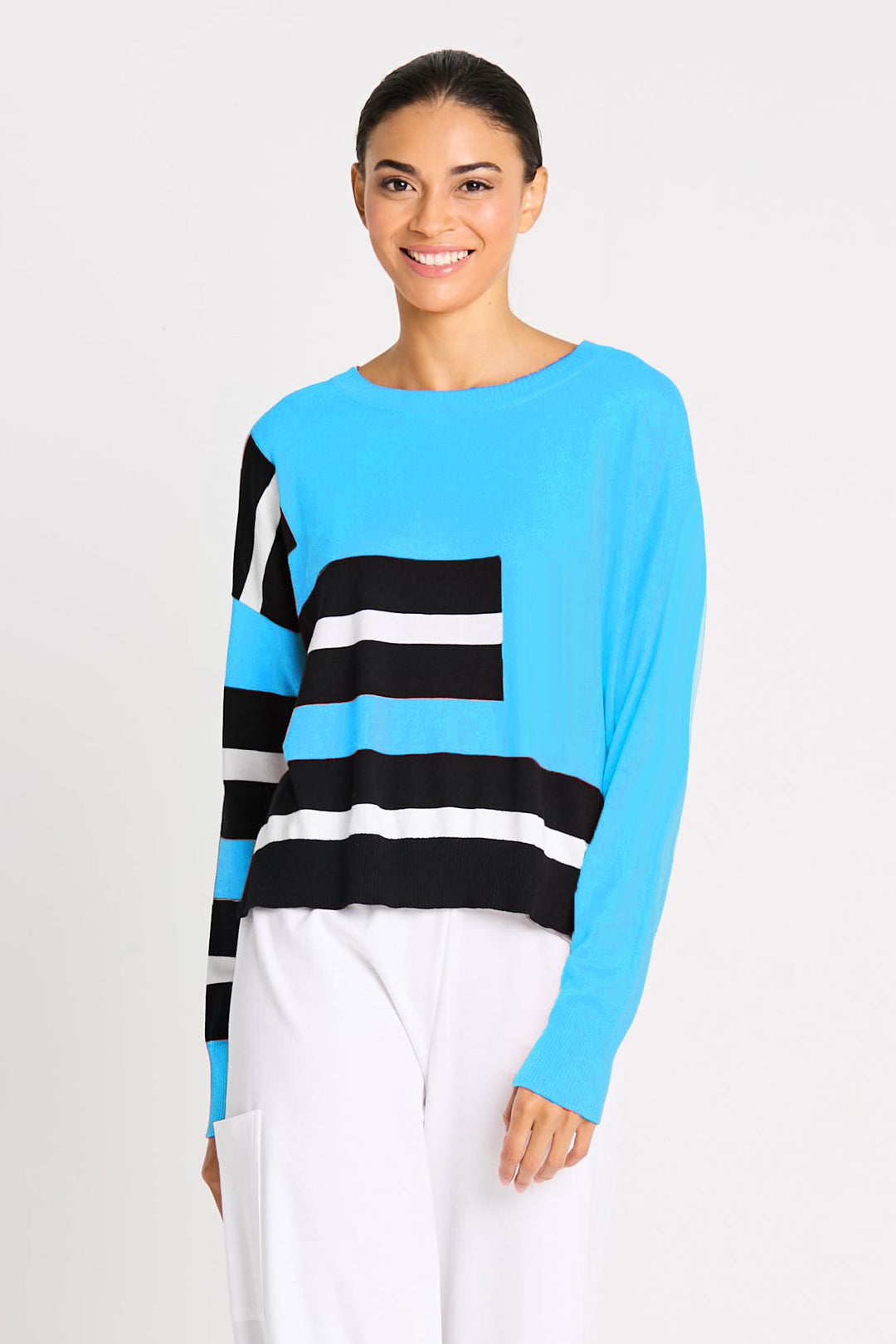 Person wearing a pink long-sleeve pima cotton top with black and white striped sleeves on a light gray background