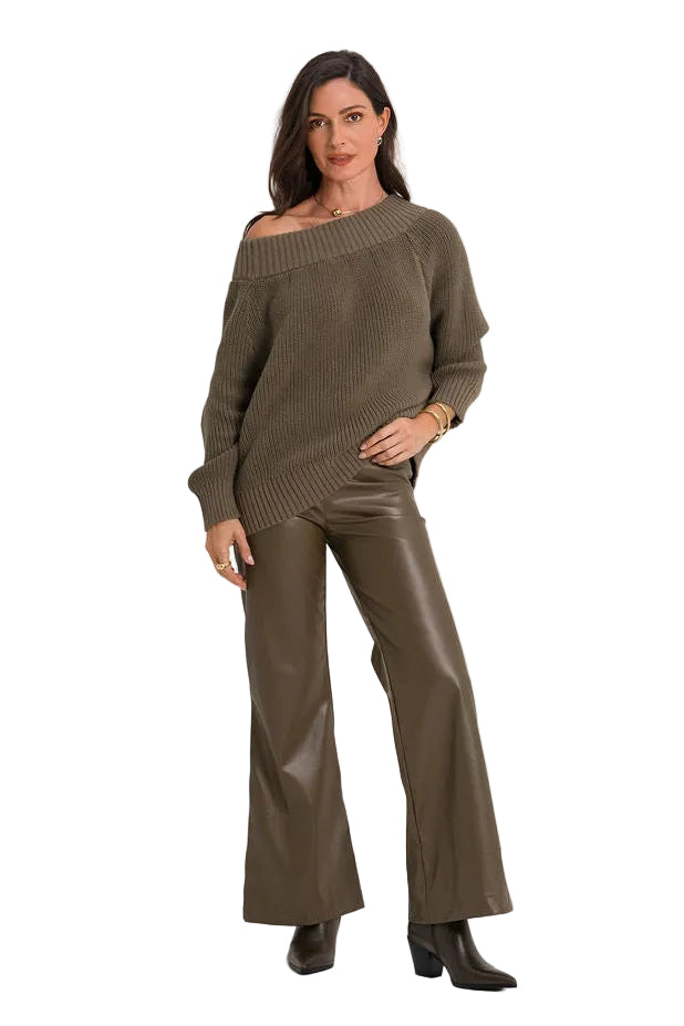 A woman modeling a matching two-piece outfit consisting of an off-the-shoulder long-sleeve knit top and wide-leg faux-leather pants in a dark olive brown color, set against a plain white studio background.