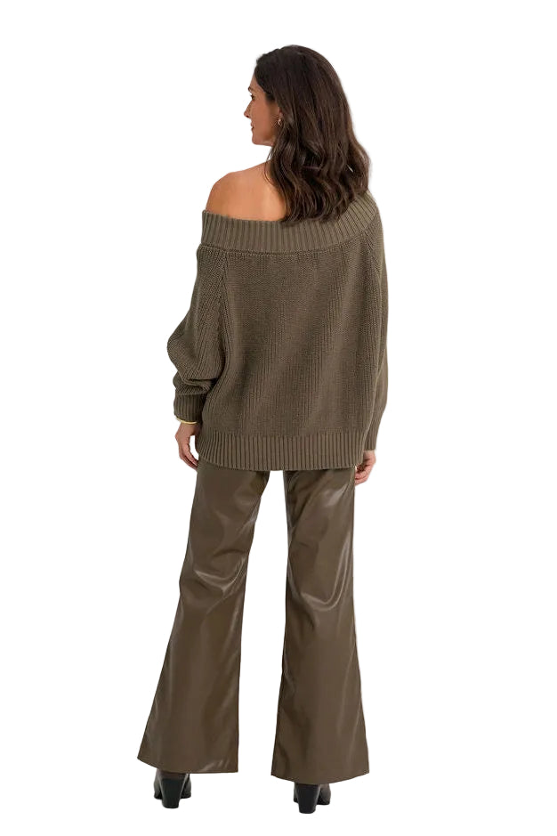 A woman is shown from the back wearing an olive brown off-the-shoulder knit sweater and matching wide-leg trousers against a plain white studio background.