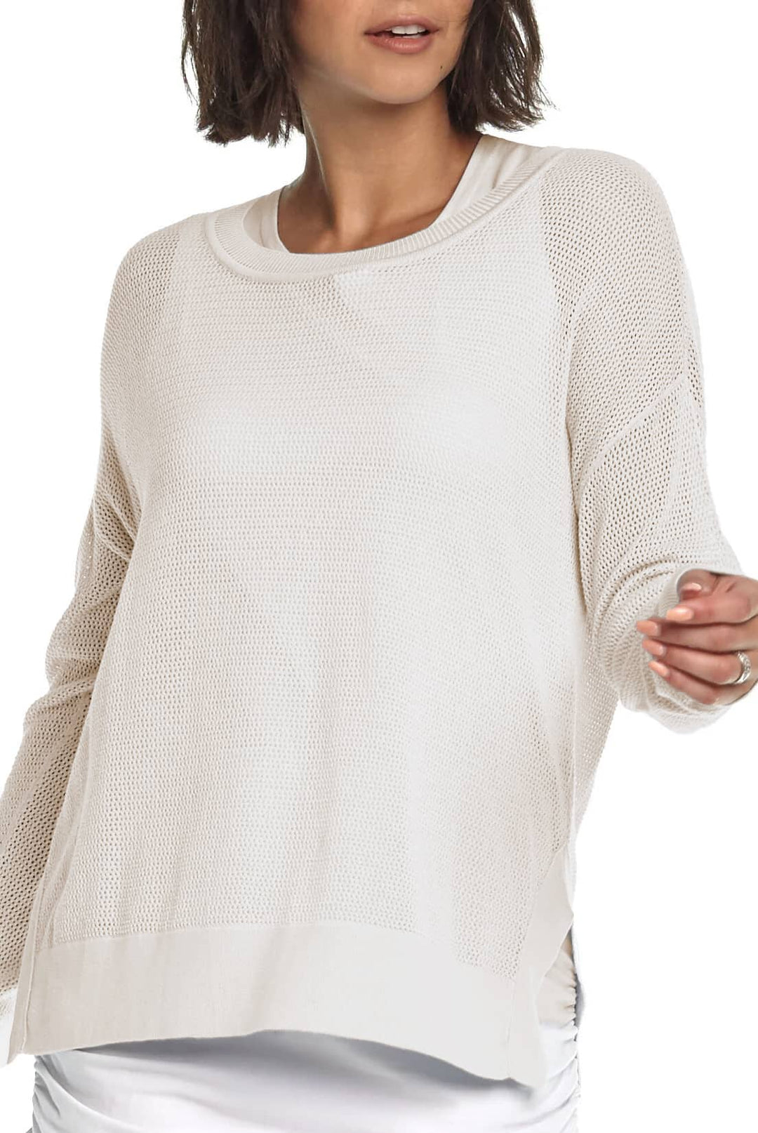 Woman wearing a blue pima cotton knit top and black wide-leg pants on a white background