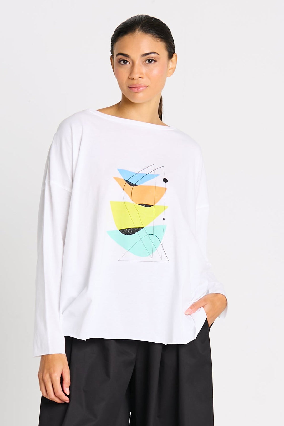 Woman wearing a luxury 100% Pima cotton white long-sleeve shirt with colorful abstract design on a plain background