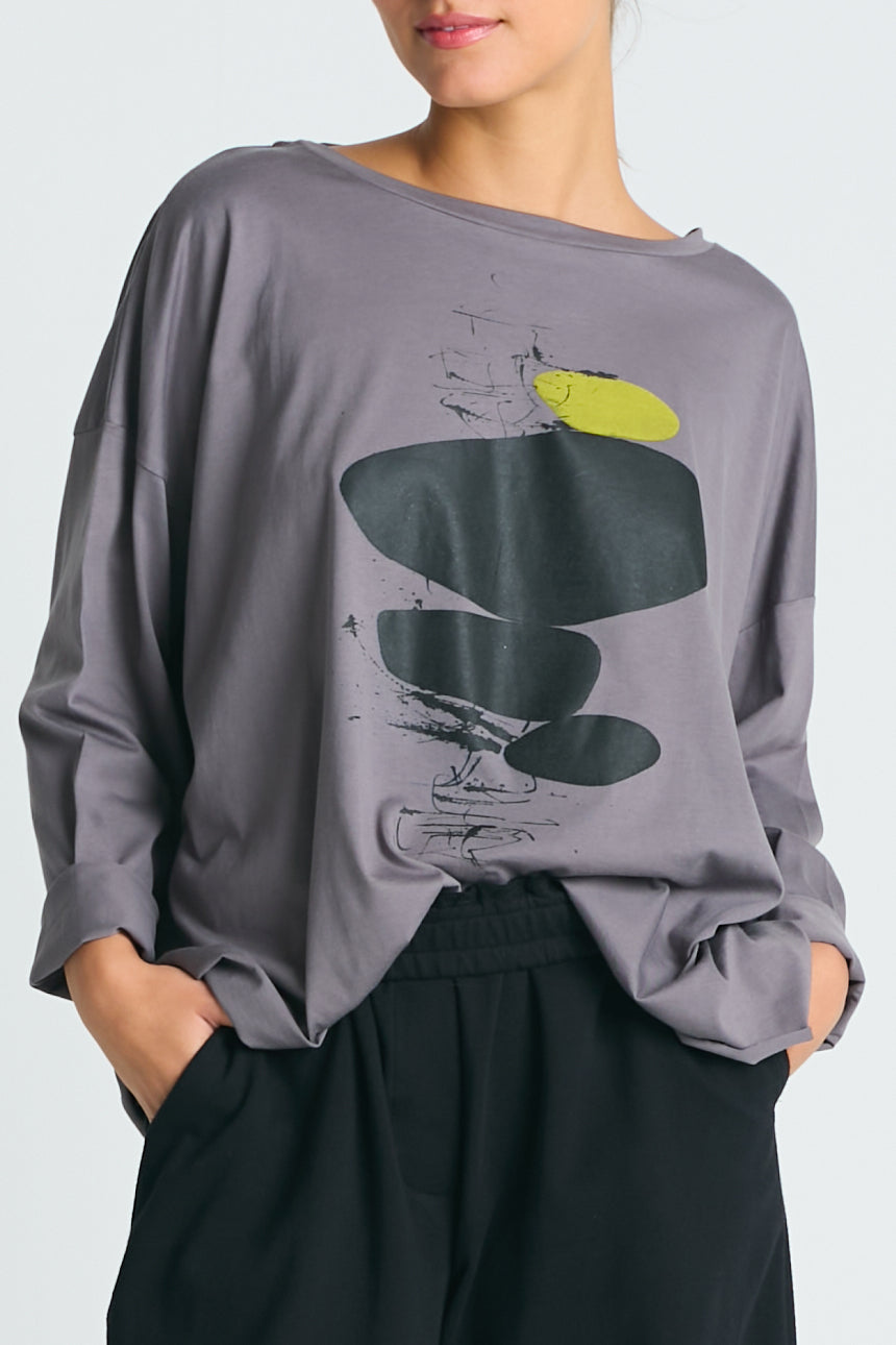 A gray Pima cotton boxy tee with a unique design featuring abstract shapes in black and green on the front.