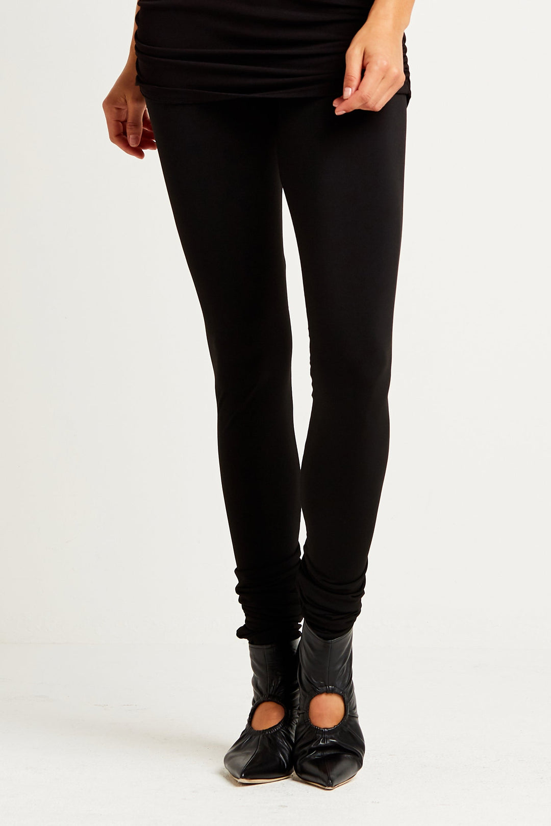 Person wearing black leggings on a white background