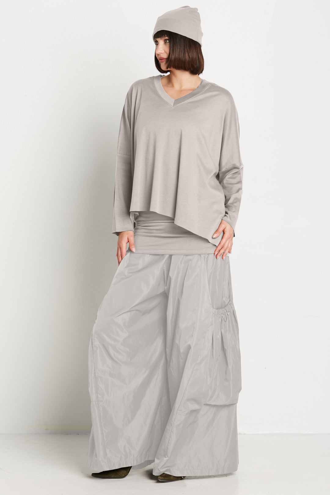 A woman wearing a gray V-neck tee and matching wide-leg pants.