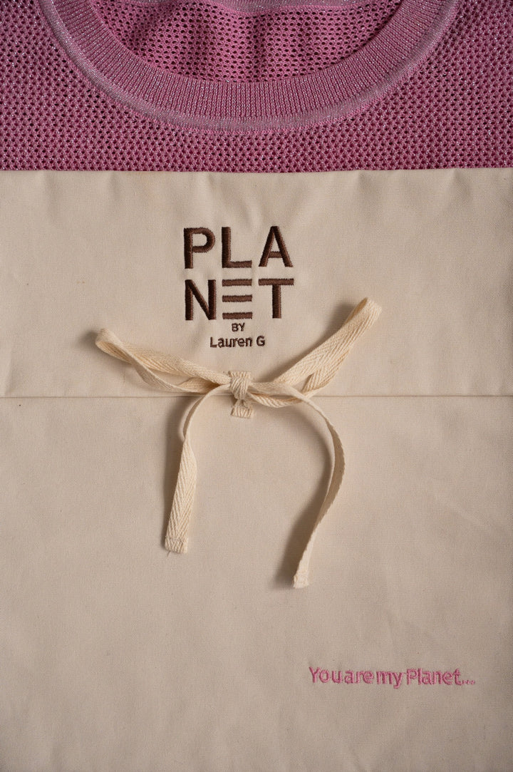 Beige mother's day tote bag with 'PLANET by Lauren G' text and pink sweater in the background